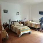 Habitación doble con cabeceros de madera y decoración personal del residente