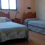 Habitación doble con dos camas, lámpara de lectura y armario